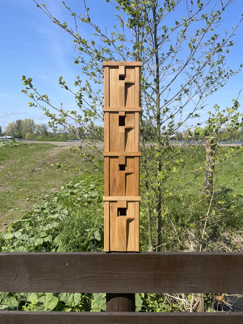 four stacked modern wood bird nesting boxes outdoors