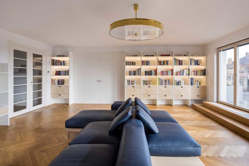 modern interior of living room with double-sided sofa and lit-up cabinets