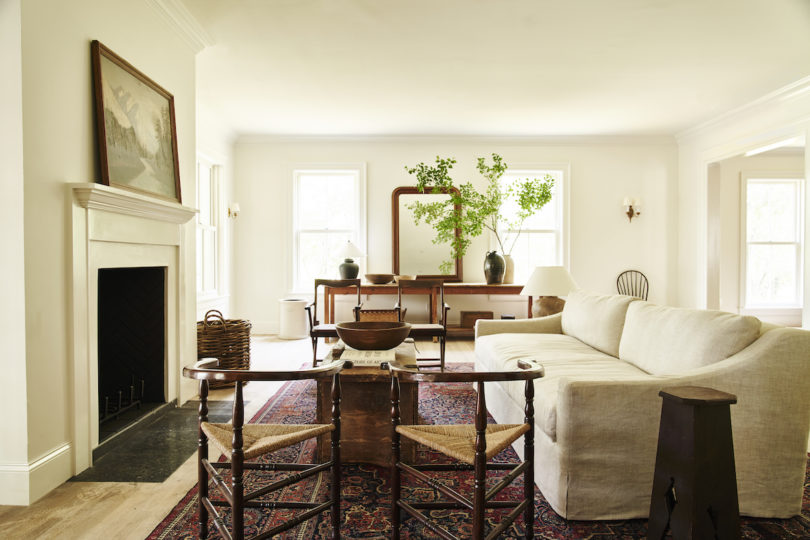 Vintage rugs, exposed beams, and a roaring fireplace creating a welcoming ambiance