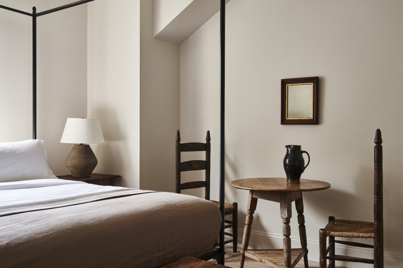 Cozy guest room in the farmhouse with a canopy bed, fireplace, and neutral color palette