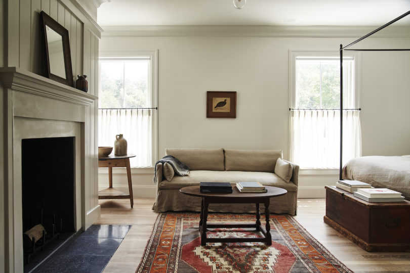 Vintage rugs, exposed beams, and a fireplace creating a welcoming ambiance