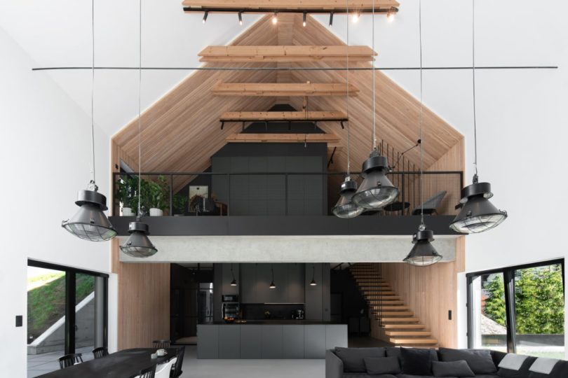 interior view of modern house facing black kitchen with loft above