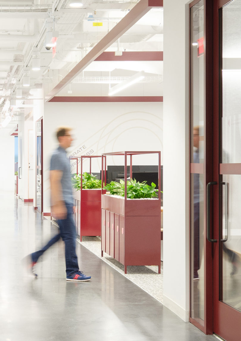 man walking past locker workstations