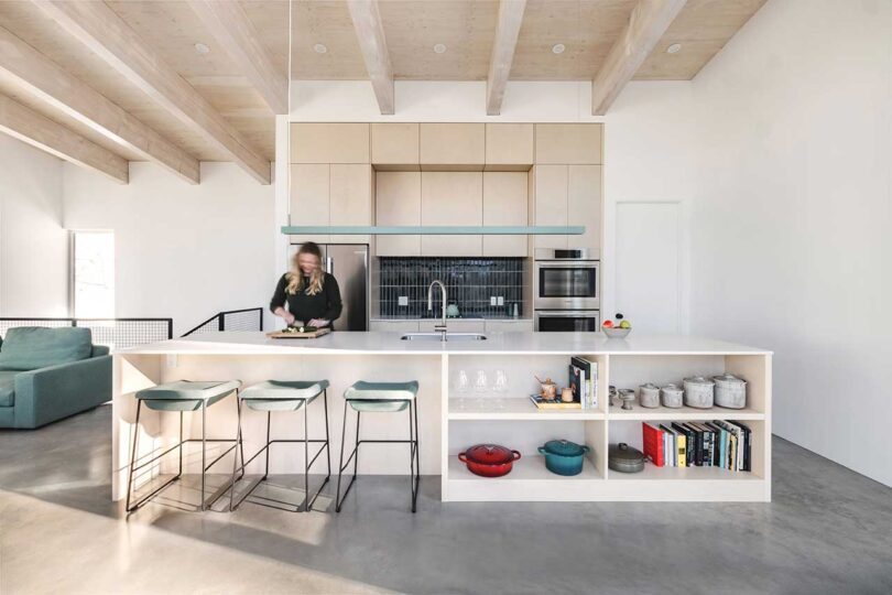 interior view of modern white kitchen with woman working at counter