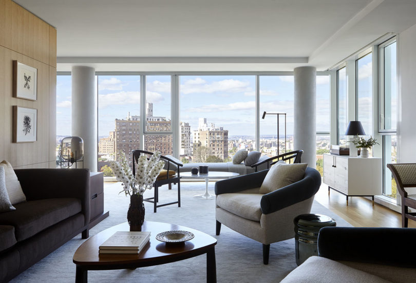 styled interior living space with lots of seating, a coffee table. and a wall of windows