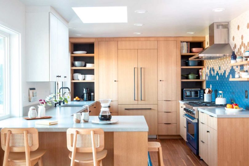 modern renovated kitchen with light wood cabinets and mosaic hexagonal tiles on the walls