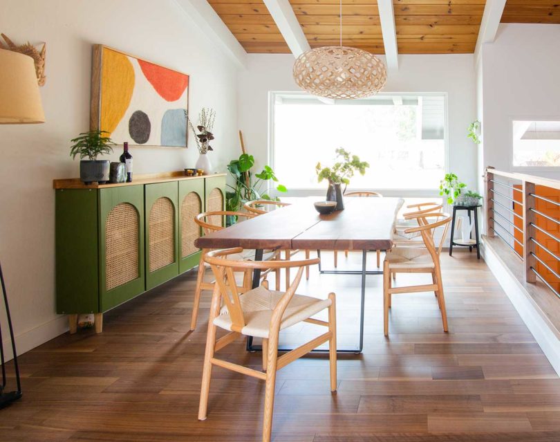 interior view of modern midcentury dining room with angled ceiling and wishbone chairs