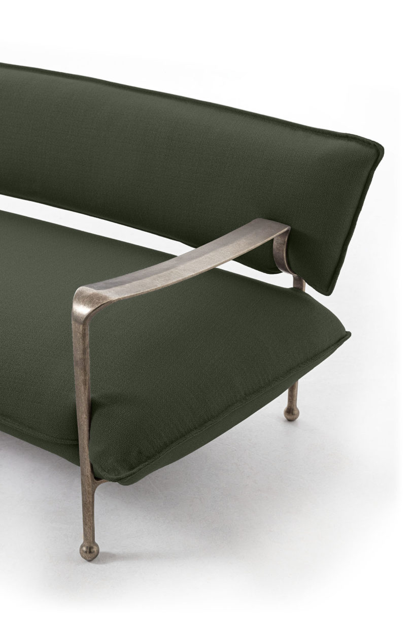 detail of curved modern sofa with silver arms and legs