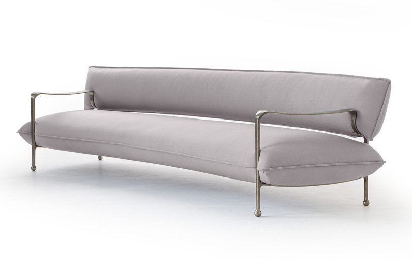 curved modern sofa with silver arms and legs