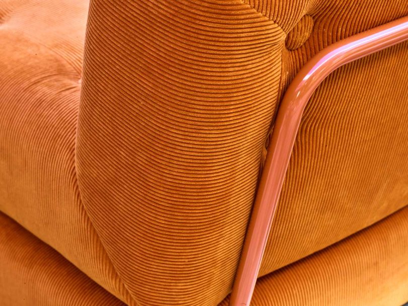 angled back view of orange corduroy chair