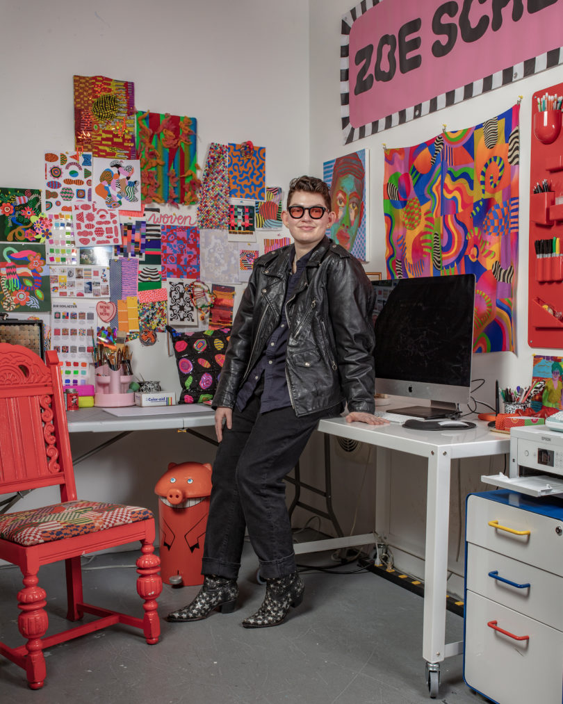 designer posing against desk in their home office