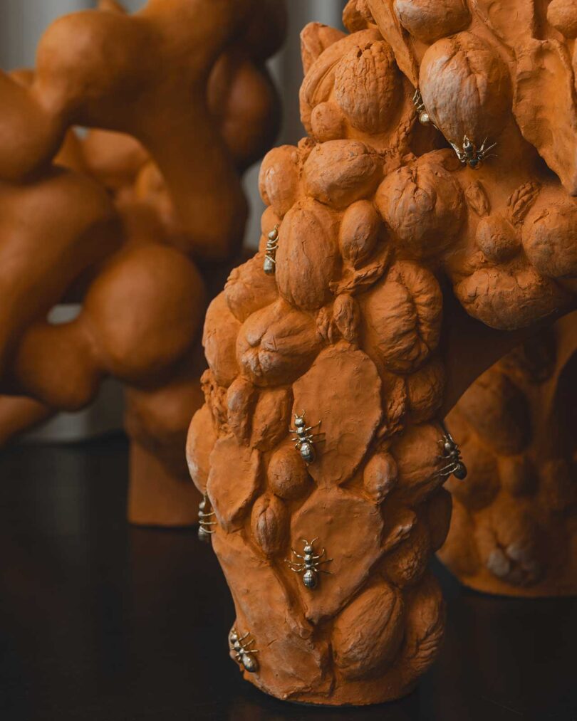 closeup view of terracotta floral chair sculpture with brass bug