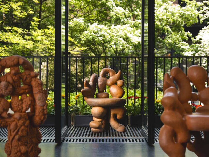 view from inside to outside terrace with large terracotta flower themed furniture