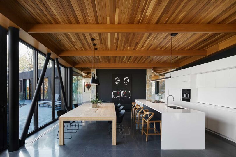 interior view of modern kitchen with white cabinets and long wood table