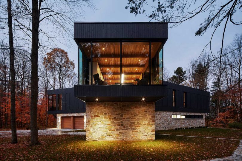 end exterior view of modern house with stone ground level and wood and glass upper level