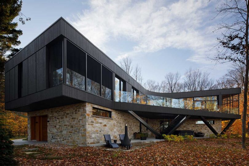 daytime exterior view of modern house with stone ground level and wood and glass upper level