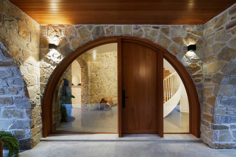 closeup exterior view of modern house with rounded wood and glass doorway