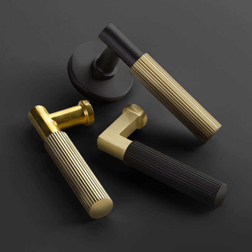 three metal door pulls on black background