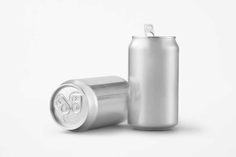 one chrome beer can lying angled on its side by one beer can standing