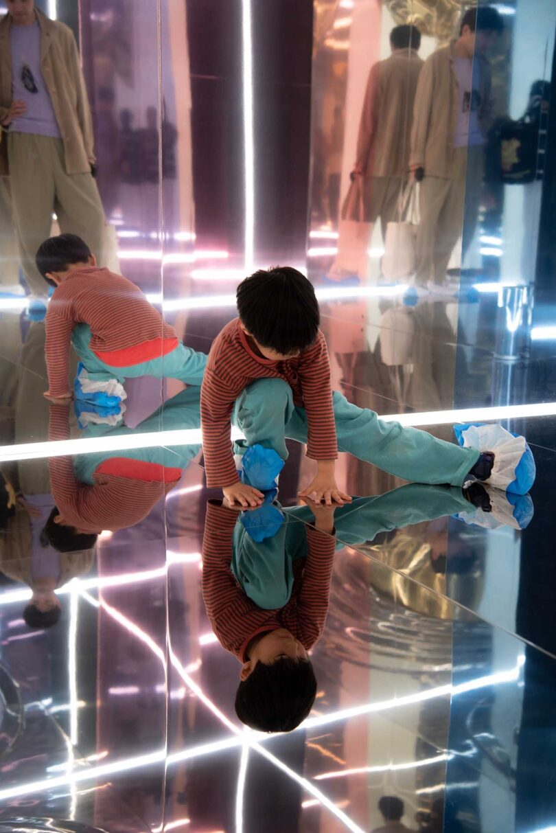 child playing on the floor of mirrored installation