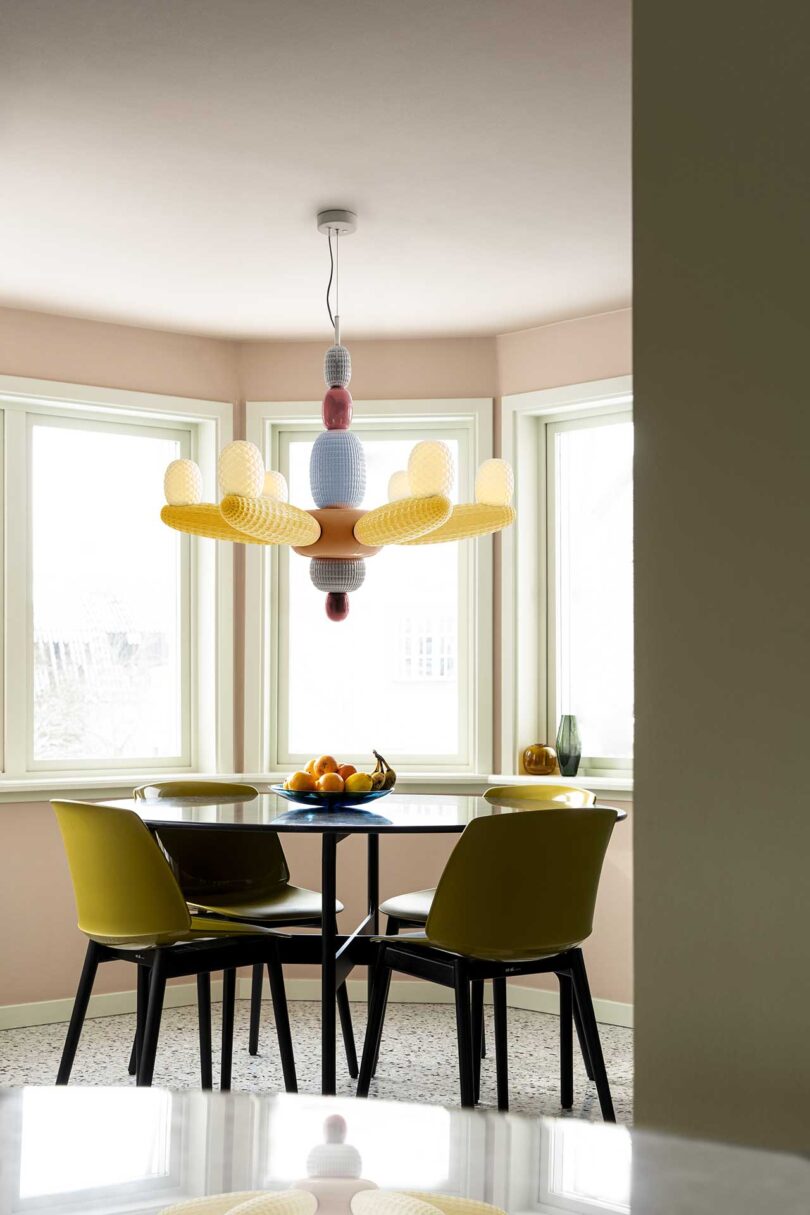 interior view of dining area with small table and chairs with unique glass chandelier above