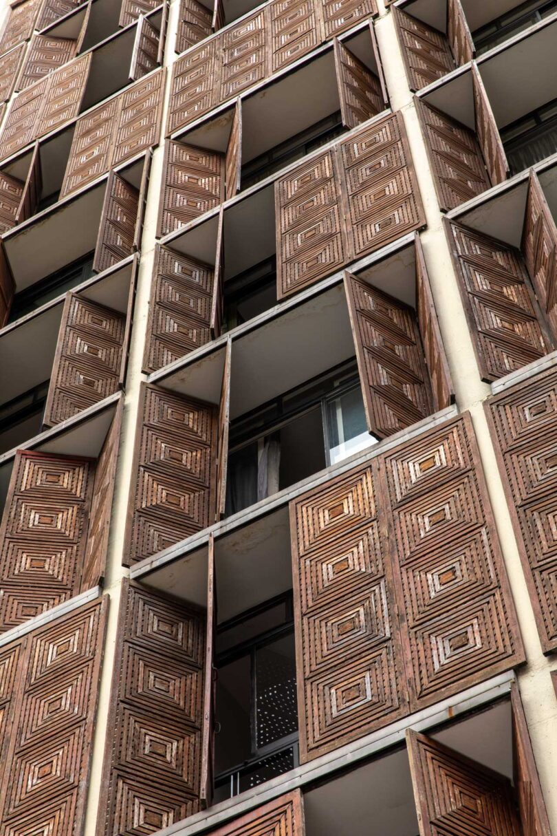 angled exterior view of modern apartment building with carved wood doors