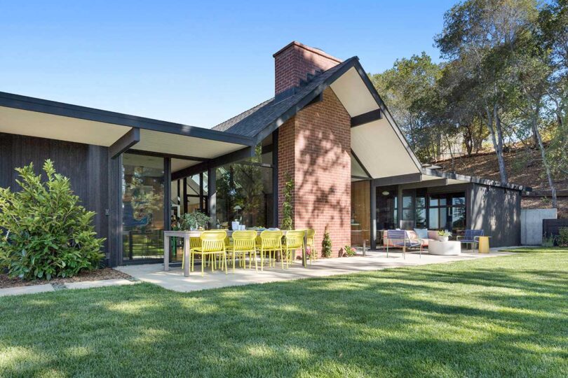 angled exterior view of mid-century modern house in backyard