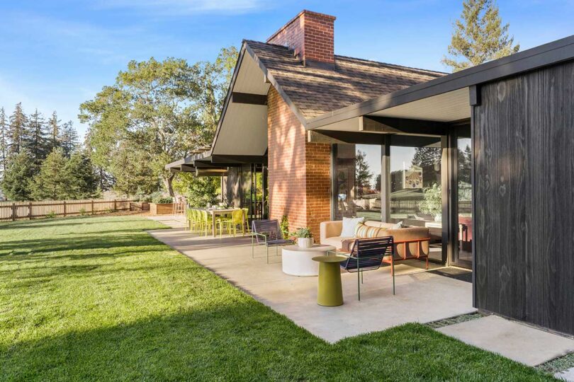 angled exterior view of mid-century modern house in backyard