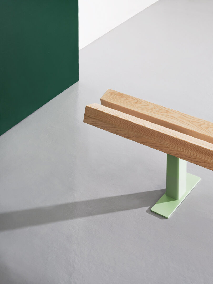 light wood bench with light green metal legs