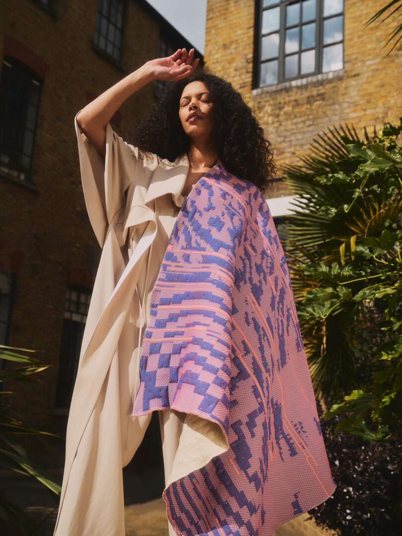 brown-skinned woman with dark hair with a throw draped over her body