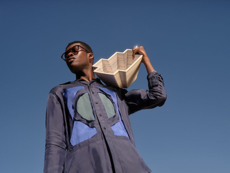 brown-skinned man with glasses holds a modern white bowl