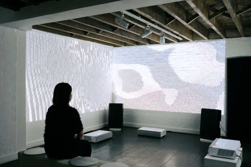 person sitting in a darkened room watching a screen