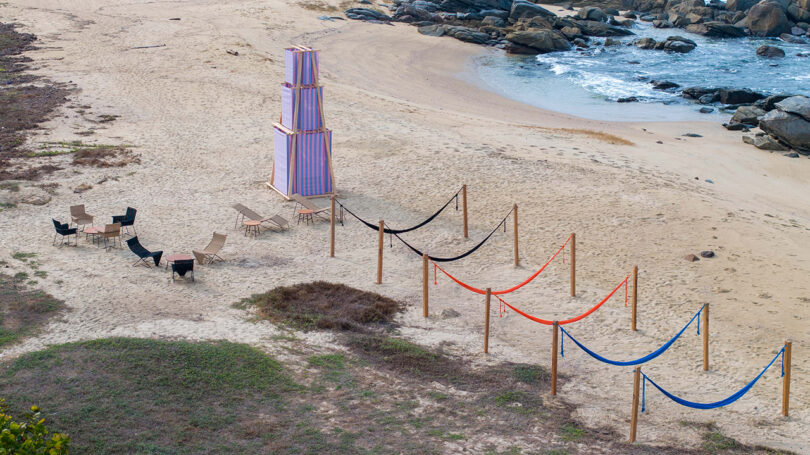 Striped pink and blue temporary shade structure installed on the beach at Casa Naila. 