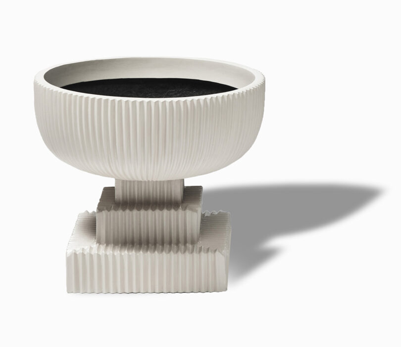 modern ivory fluted urn on white background